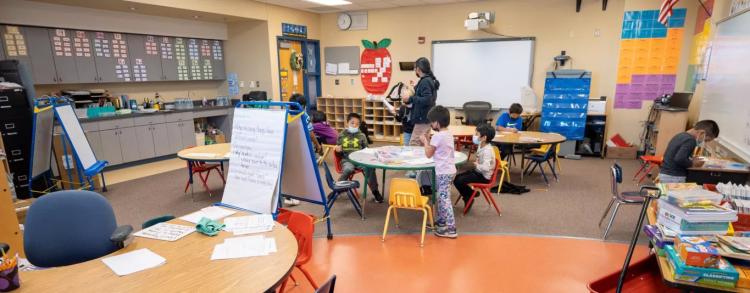 students working on various projects and teacher in classroom