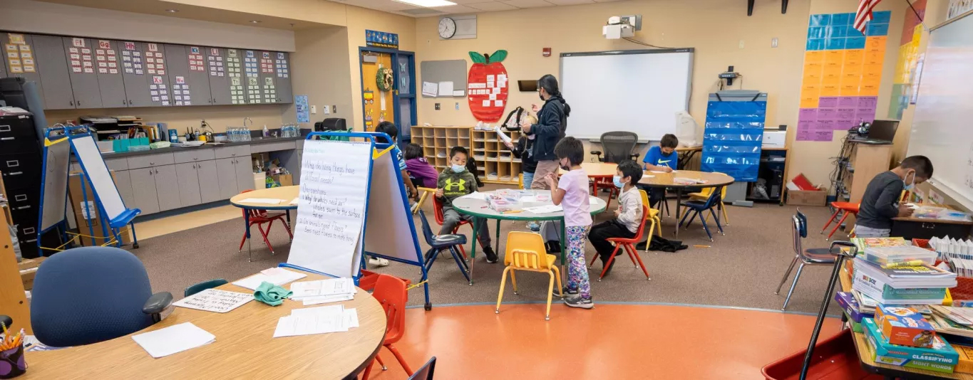 students working on various projects and teacher in classroom